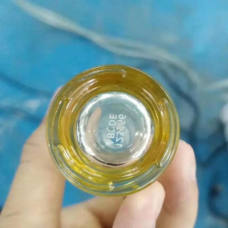 UV laser marking on the base of a glass cosmetic bottle
